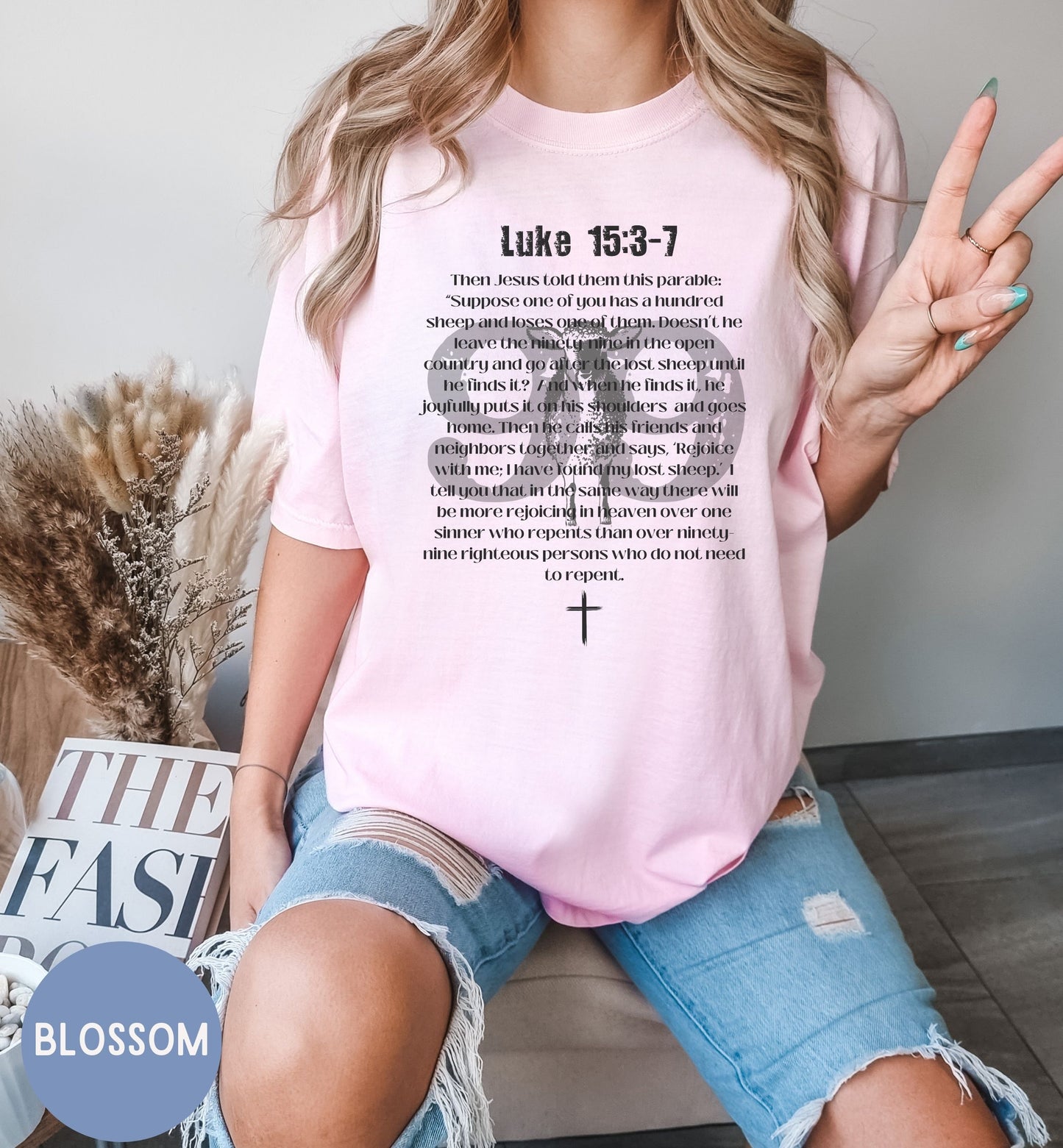 a woman sitting on a couch wearing a pink shirt