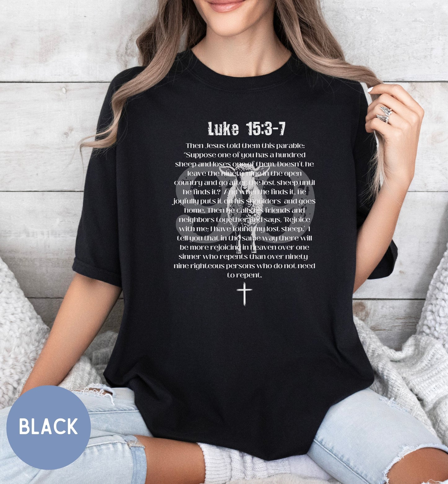 a woman wearing a black t - shirt with a cross on it