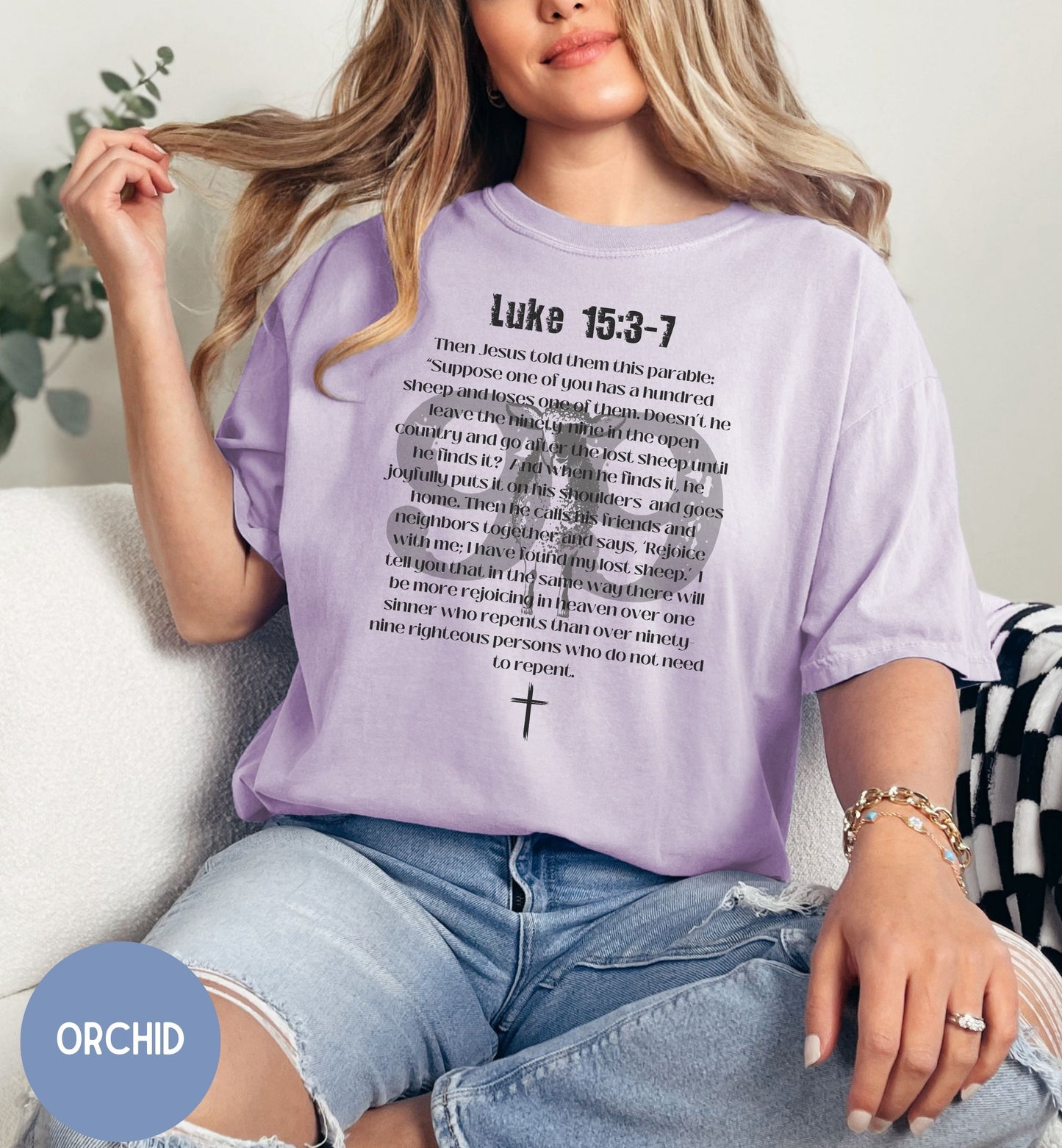 a woman sitting on a couch wearing a purple shirt