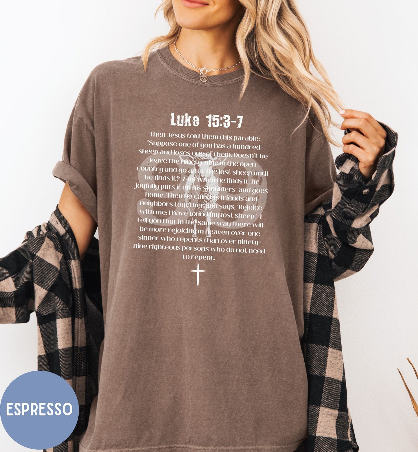 a woman wearing a brown shirt with a cross on it