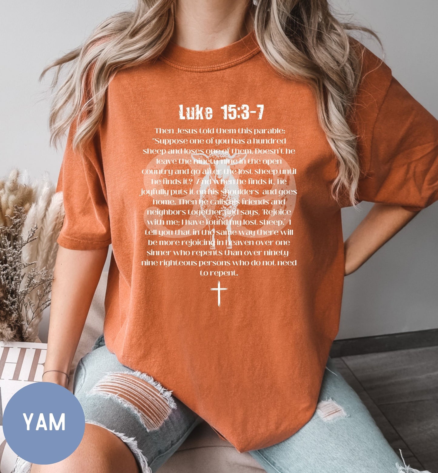 a woman wearing an orange shirt with a cross on it