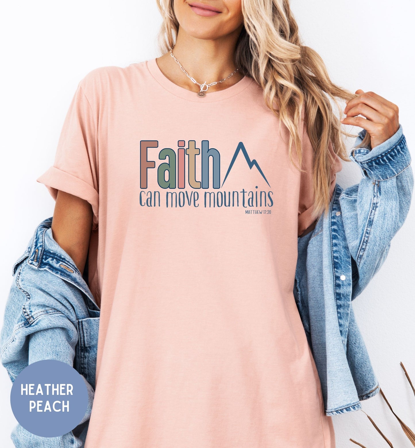 a woman wearing a pink shirt that says faith can move mountains