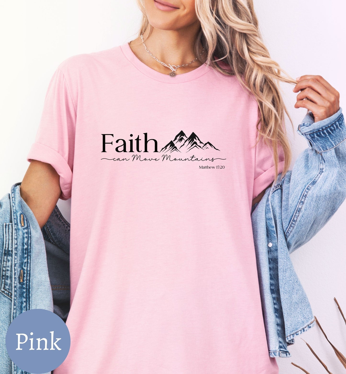 a woman wearing a pink shirt with the words faith on it
