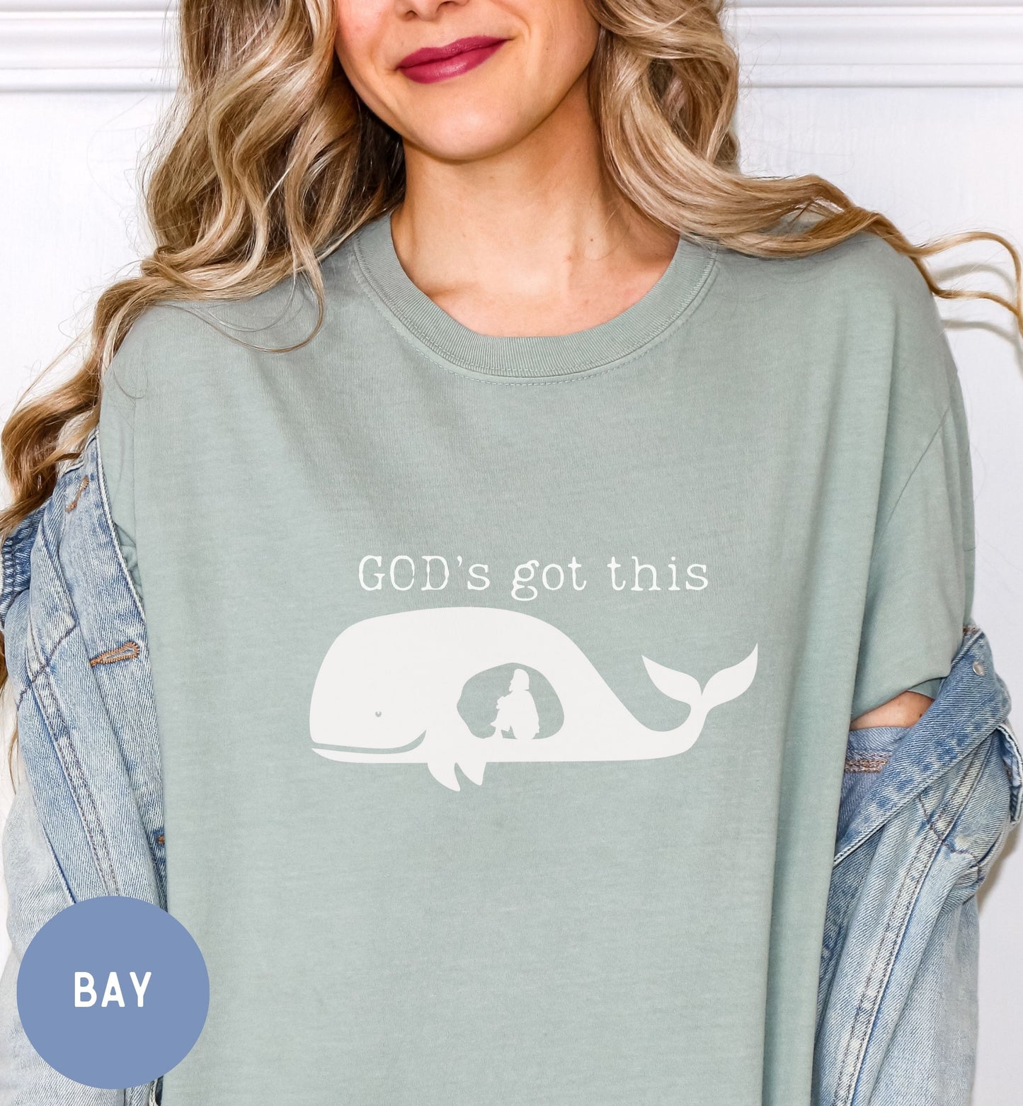 a woman wearing a green shirt with a whale on it