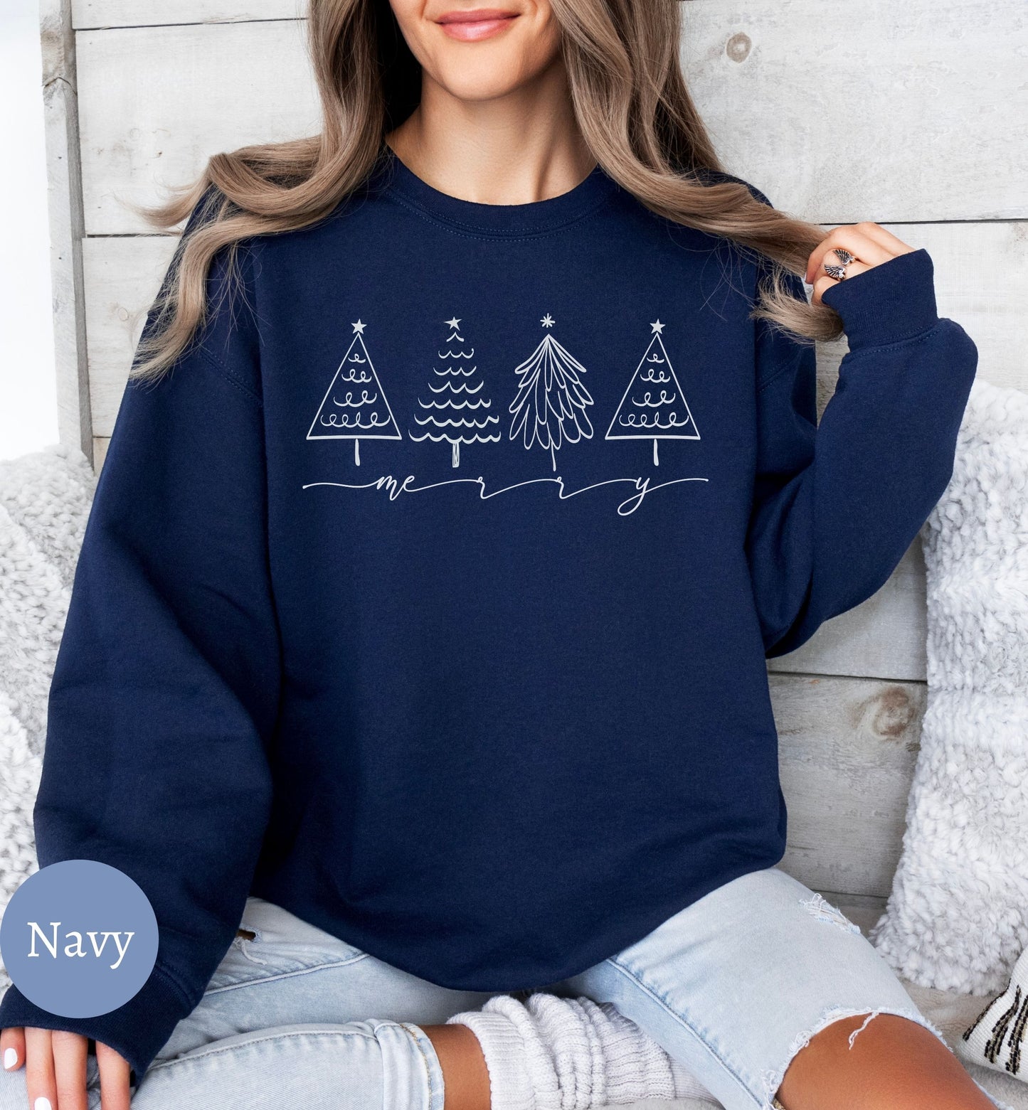 a woman sitting on a couch wearing a navy sweatshirt