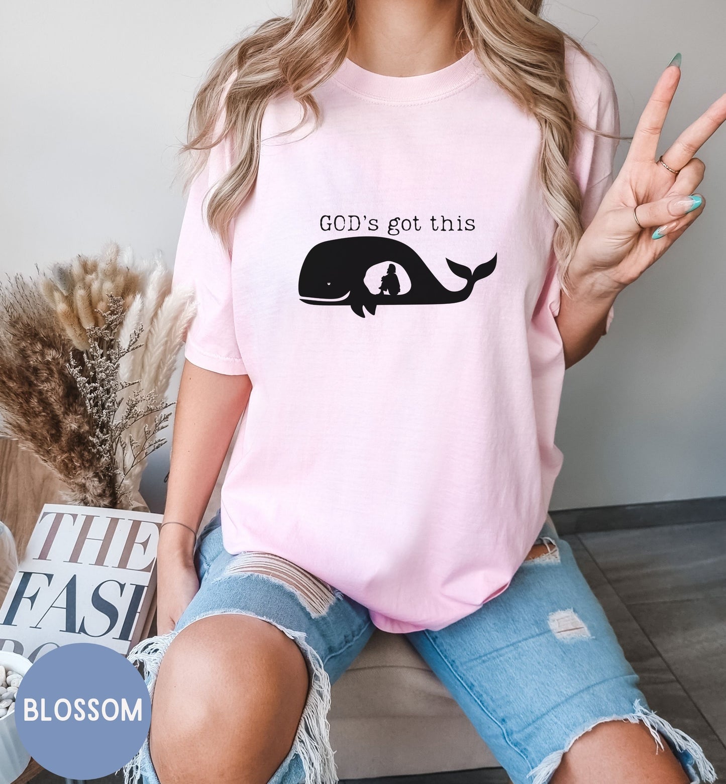a woman wearing a pink shirt that says god's got this
