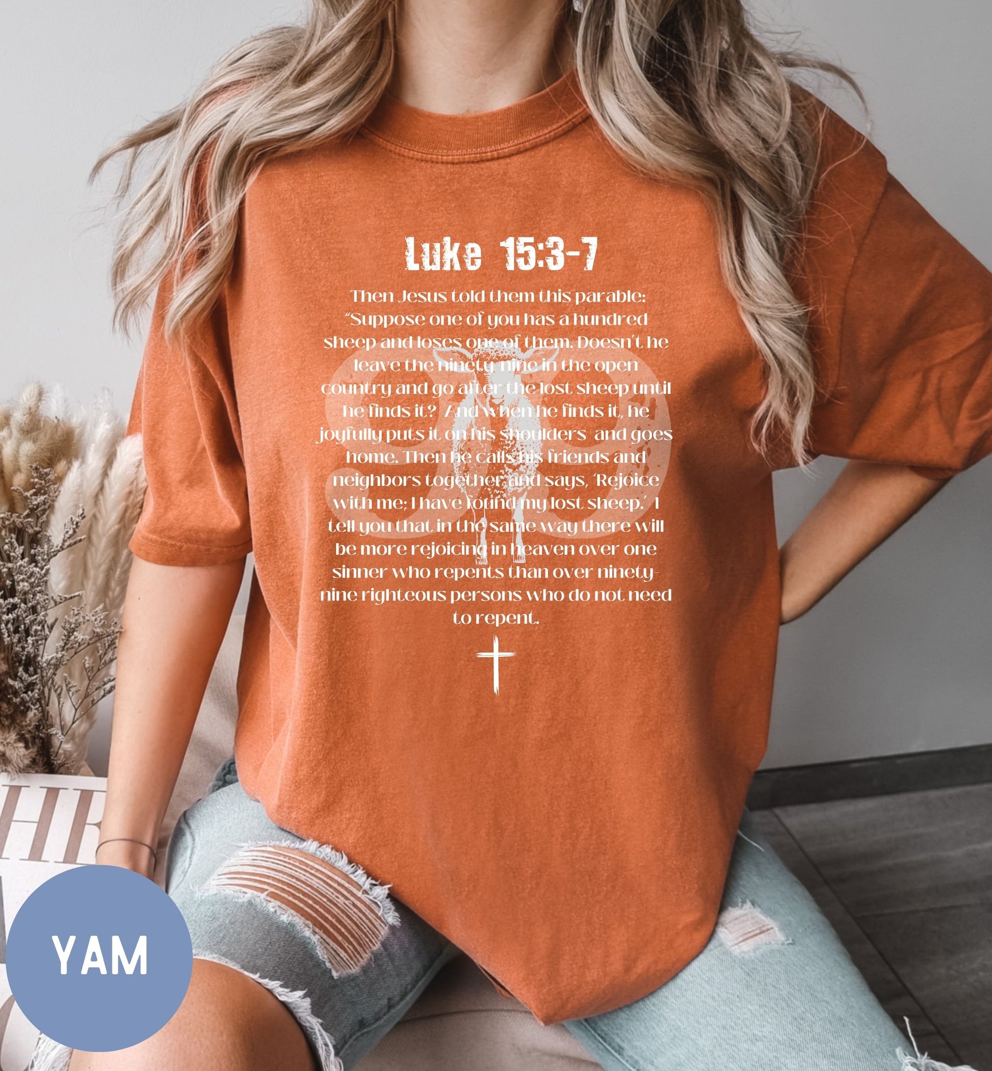 a woman wearing an orange shirt with a cross on it