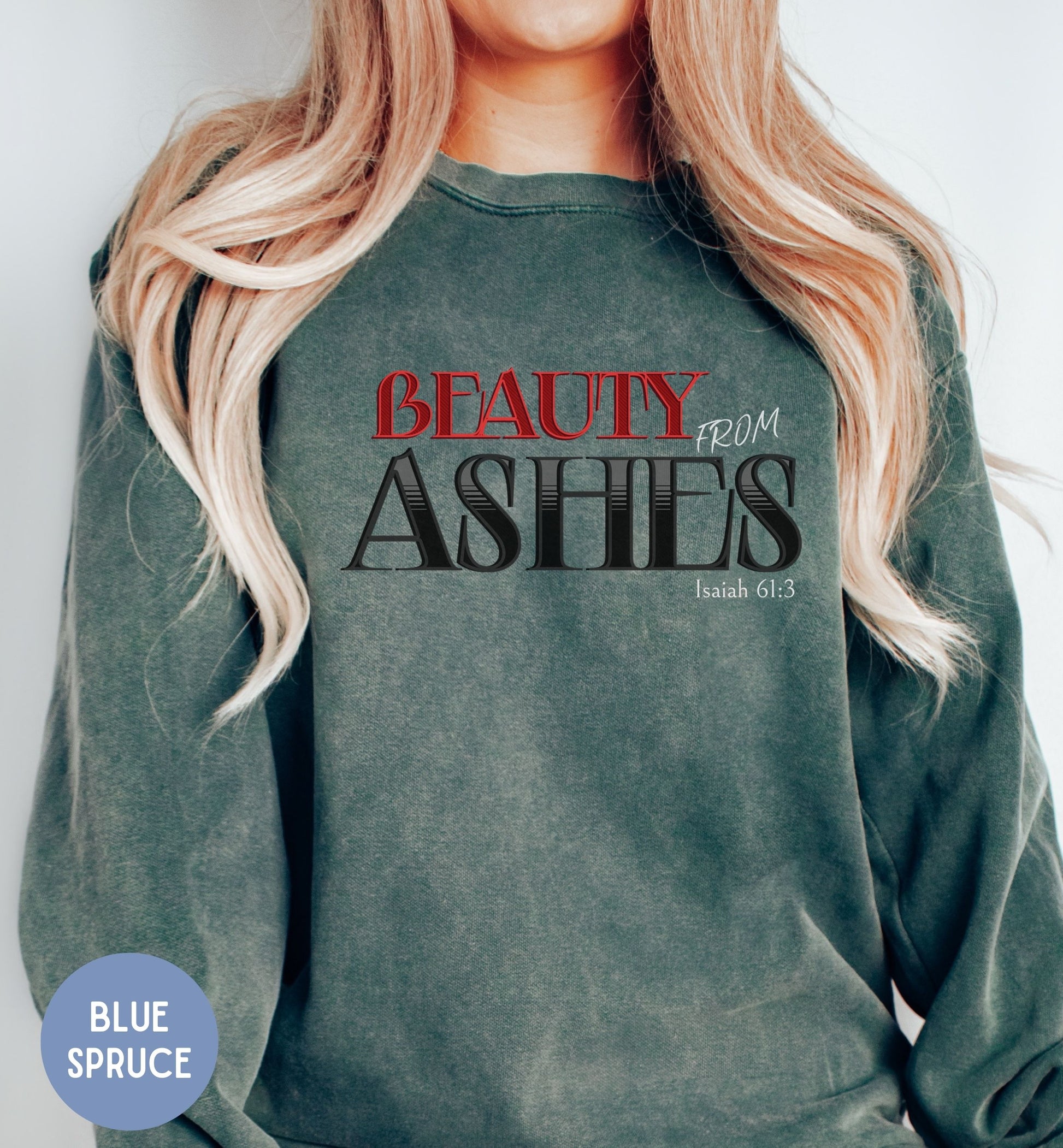 a woman wearing a green sweatshirt with the words beauty from ashes printed on it