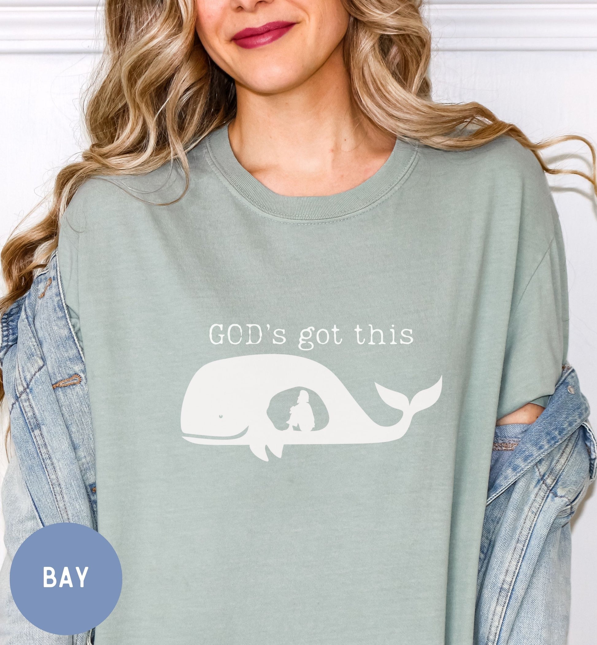 a woman wearing a green shirt with a whale on it