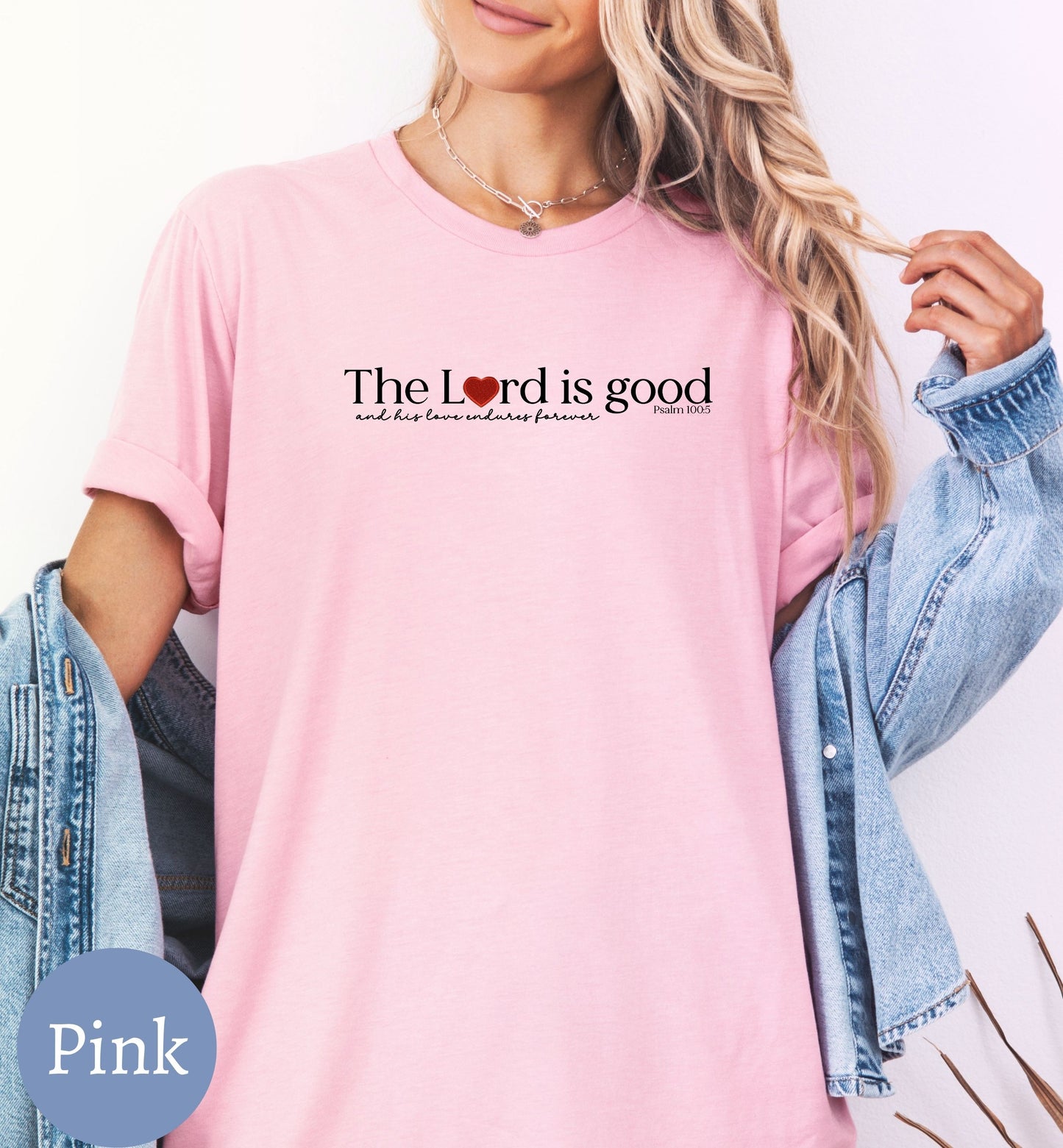 a woman wearing a pink shirt with the words the lord is good on it