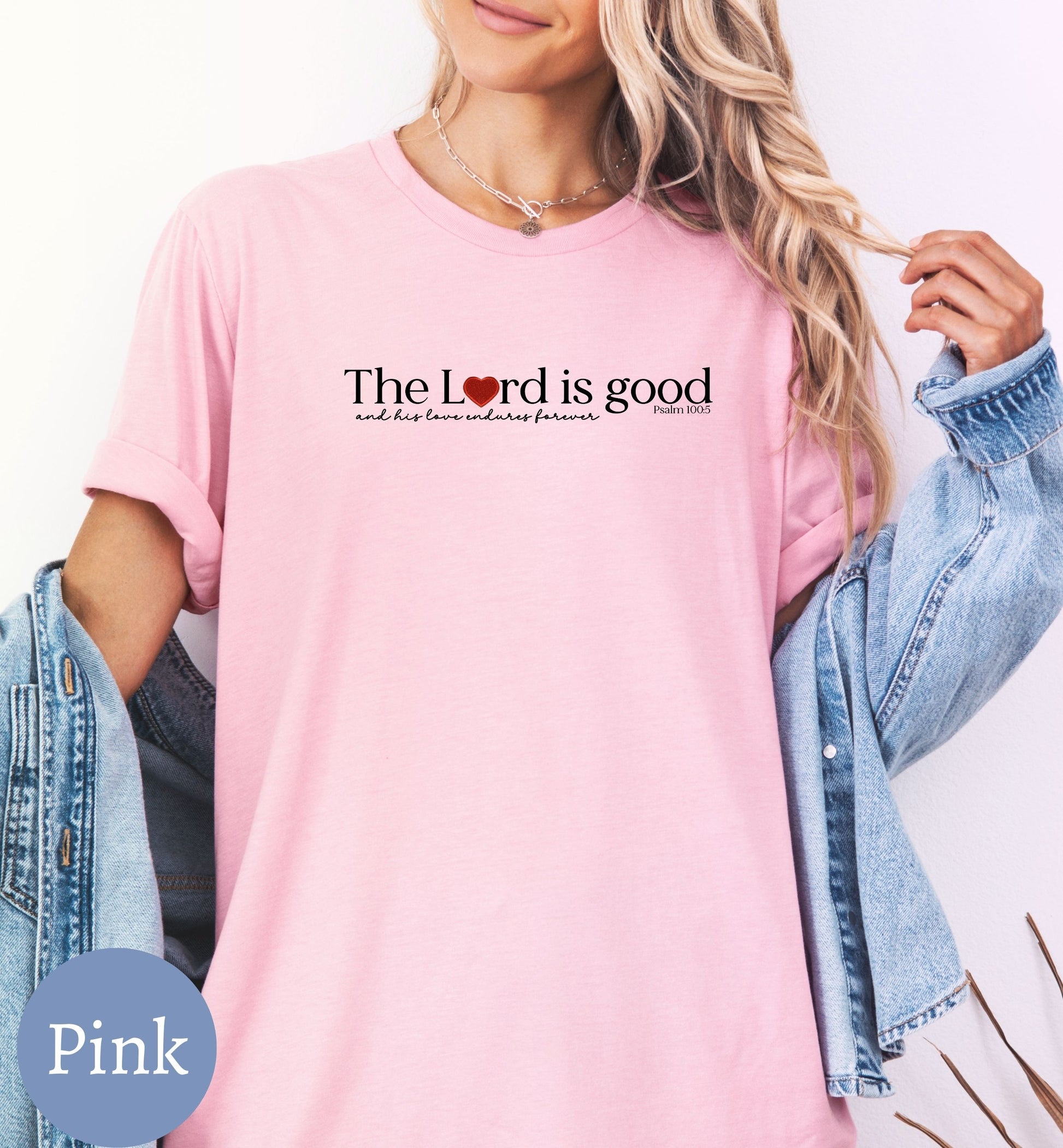 a woman wearing a pink shirt with the words the lord is good on it